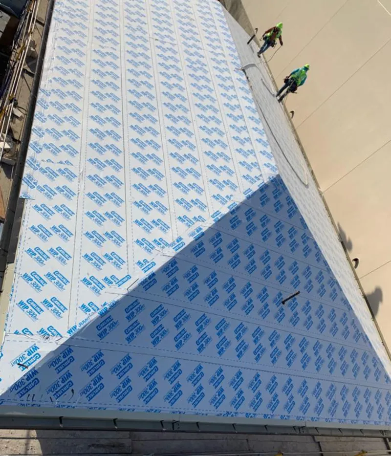 Professional roofers installing underlayment on a metal roof in Conneaut